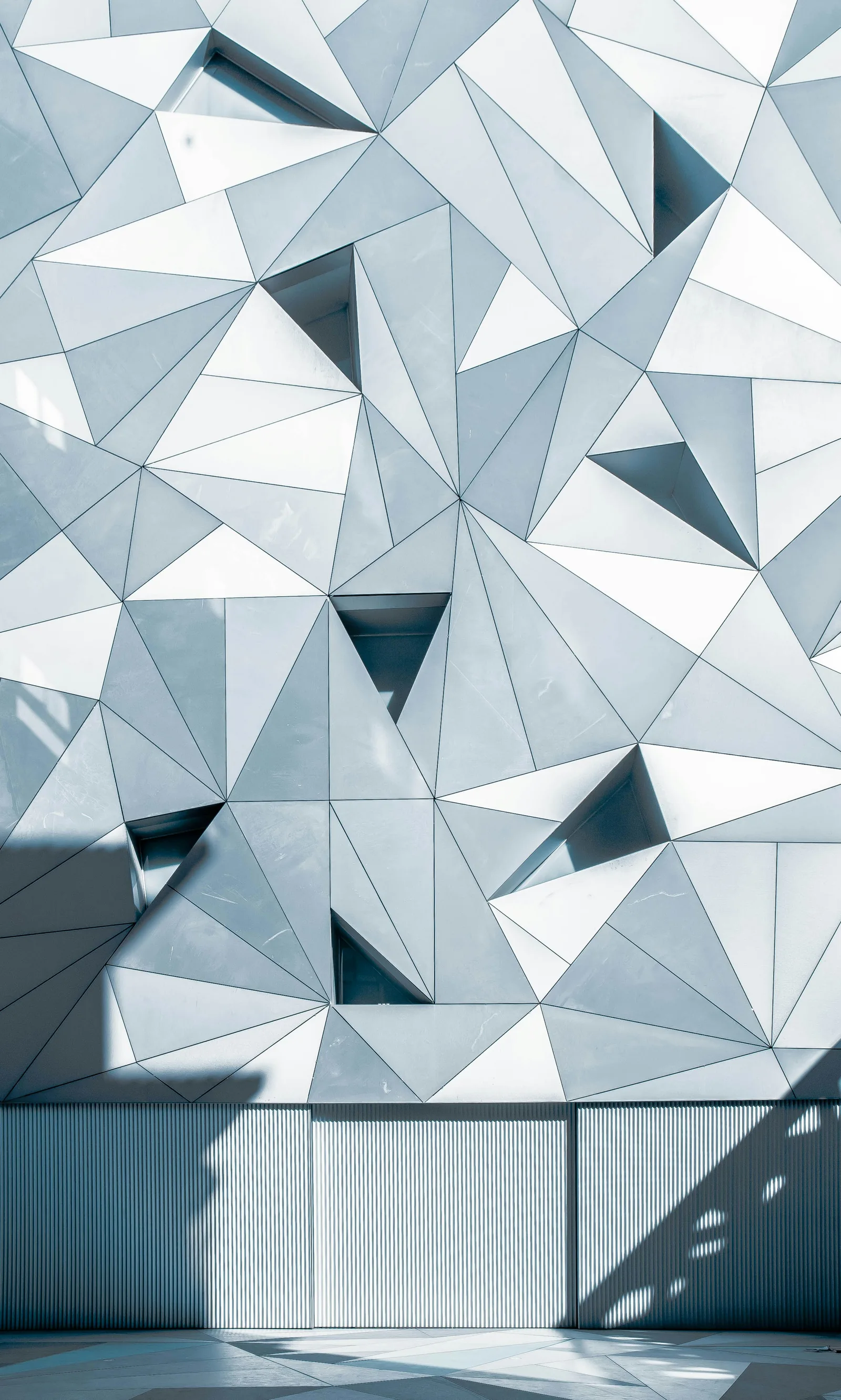 Angular blue-gray architectural panels forming a precise geometric facade.